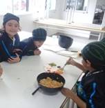La imagen puede contener: 2 personas, personas sonriendo, personas sentadas, comida e interior