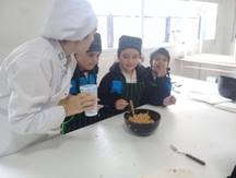La imagen puede contener: 2 personas, personas sonriendo, personas sentadas, comida e interior